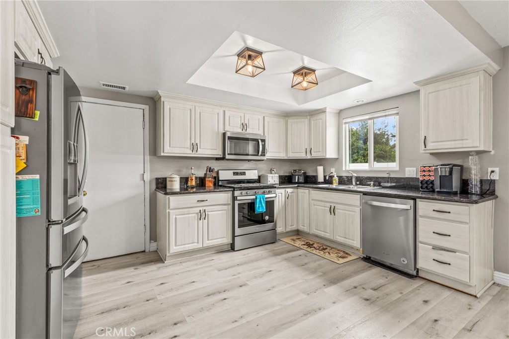3998 Bluff Street Norco, CA 92860 - Photo 14 of 74 a kitchen with granite countertop a refrigerator oven stove and sink