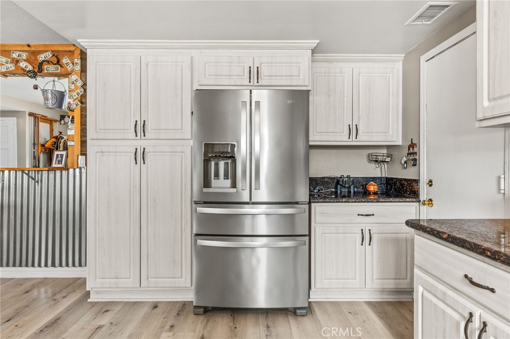 3998 Bluff Street Norco, CA 92860 - Photo 16 of 74 a kitchen with stainless steel appliances granite countertop a refrigerator oven a white stove and white cabinets
