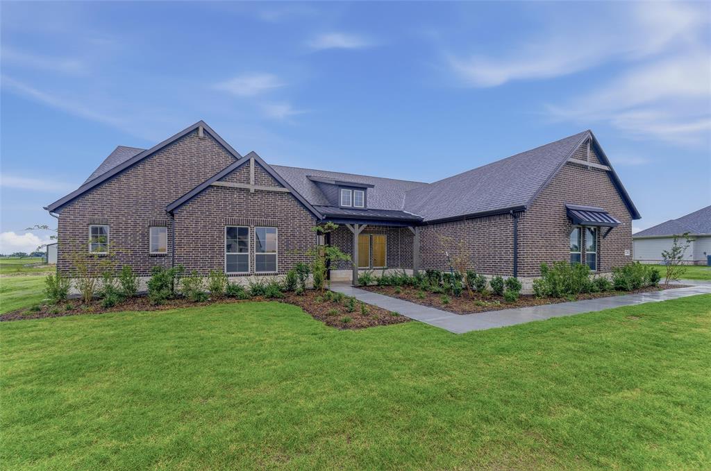 2208 Continent Court Krum, TX 76249 - Photo 4 of 26 Brick exterior with dark gray shingles, featuring a covered entry porch, multiple gables, and a window awning
