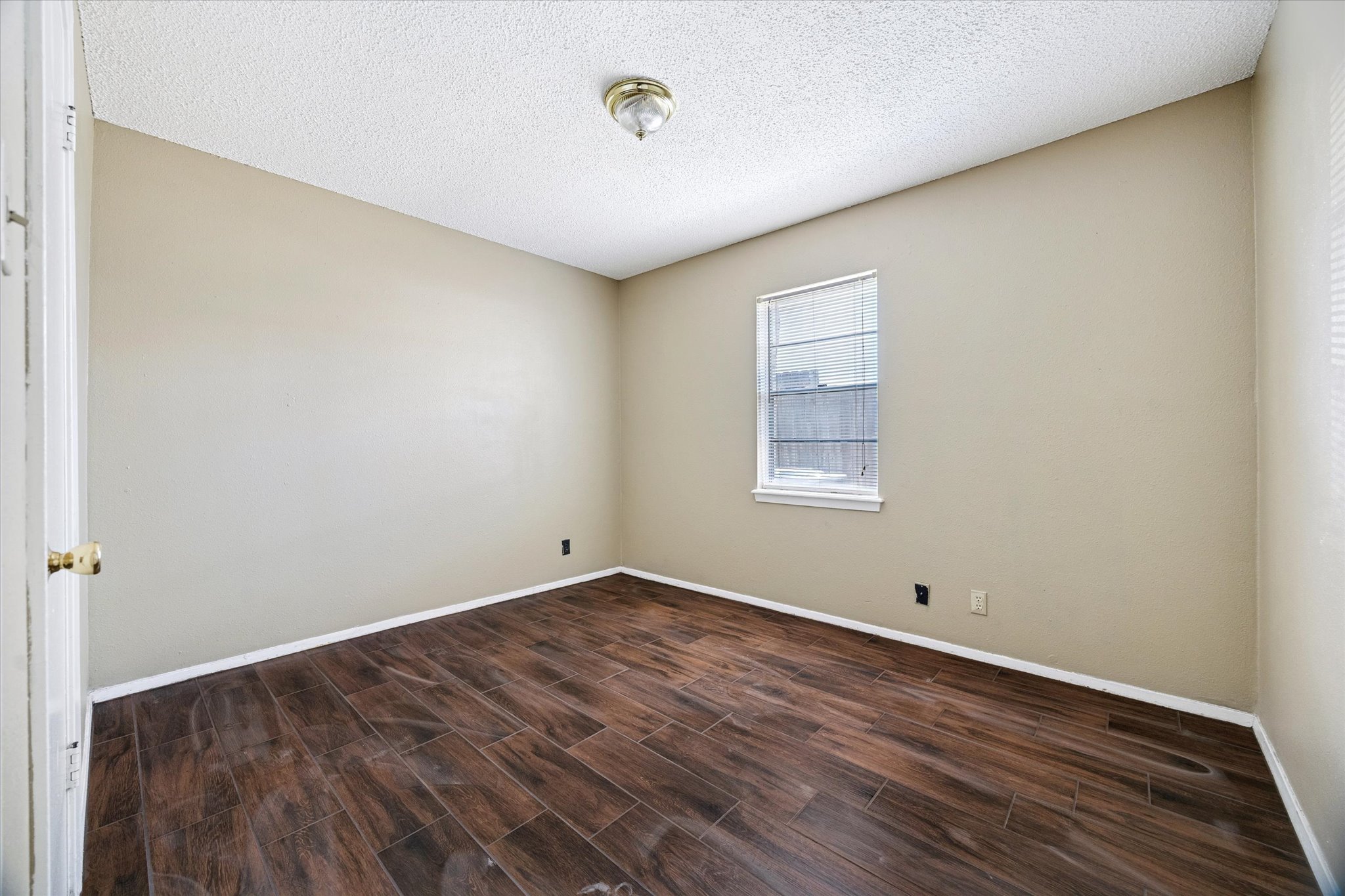 908 Kirschner Place, Unit B Austin, TX 78758 - Photo 8 of 10 Empty room featuring a textured ceiling and wood finish floors