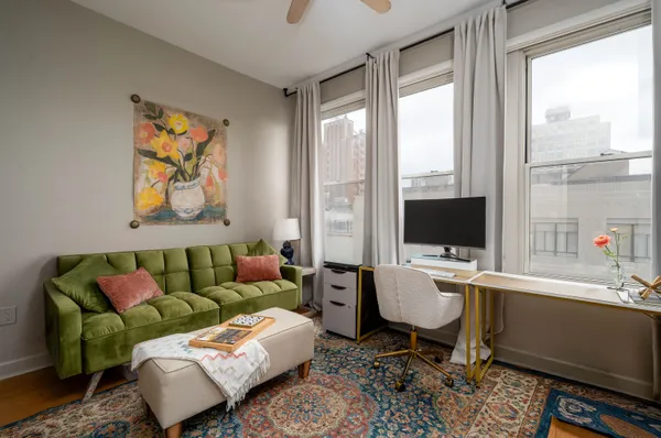 a living room with furniture a flat screen tv and a floor to ceiling window