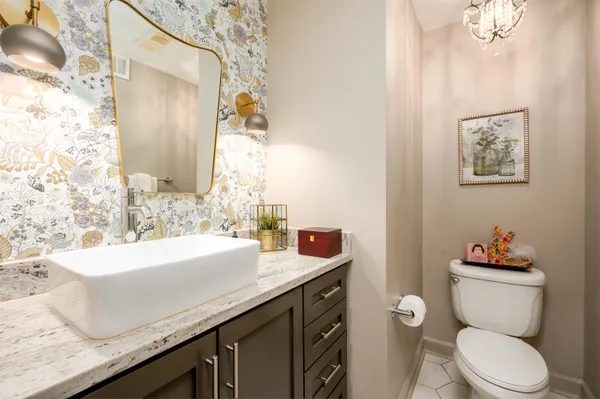 a bathroom with a granite countertop toilet sink and mirror