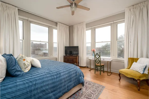 a bedroom with a bed and large windows