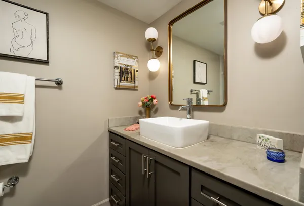 a bathroom with a granite countertop sink and a mirror