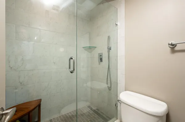 a white toilet next to a bathroom