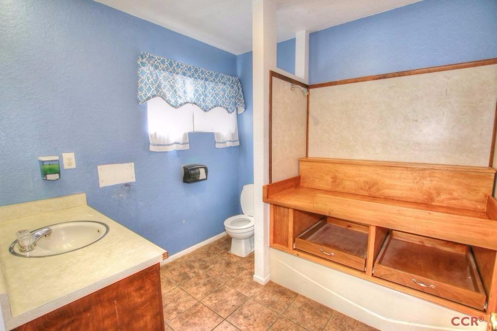 12275 Alondra Road Atascadero, CA 93422 - Photo 20 of 25 a bathroom with a granite countertop toilet sink and mirror