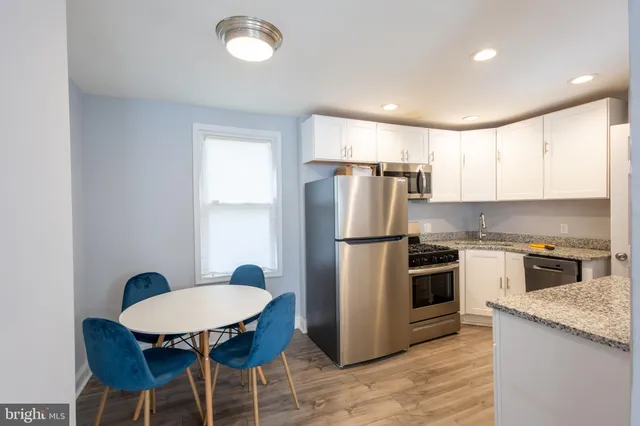 a kitchen with refrigerator cabinets dining table and chairs