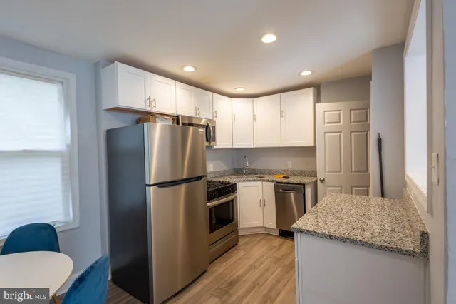 a kitchen with a refrigerator a stove top oven a sink and cabinets