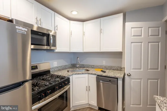 a kitchen with stainless steel appliances a stove microwave and refrigerator