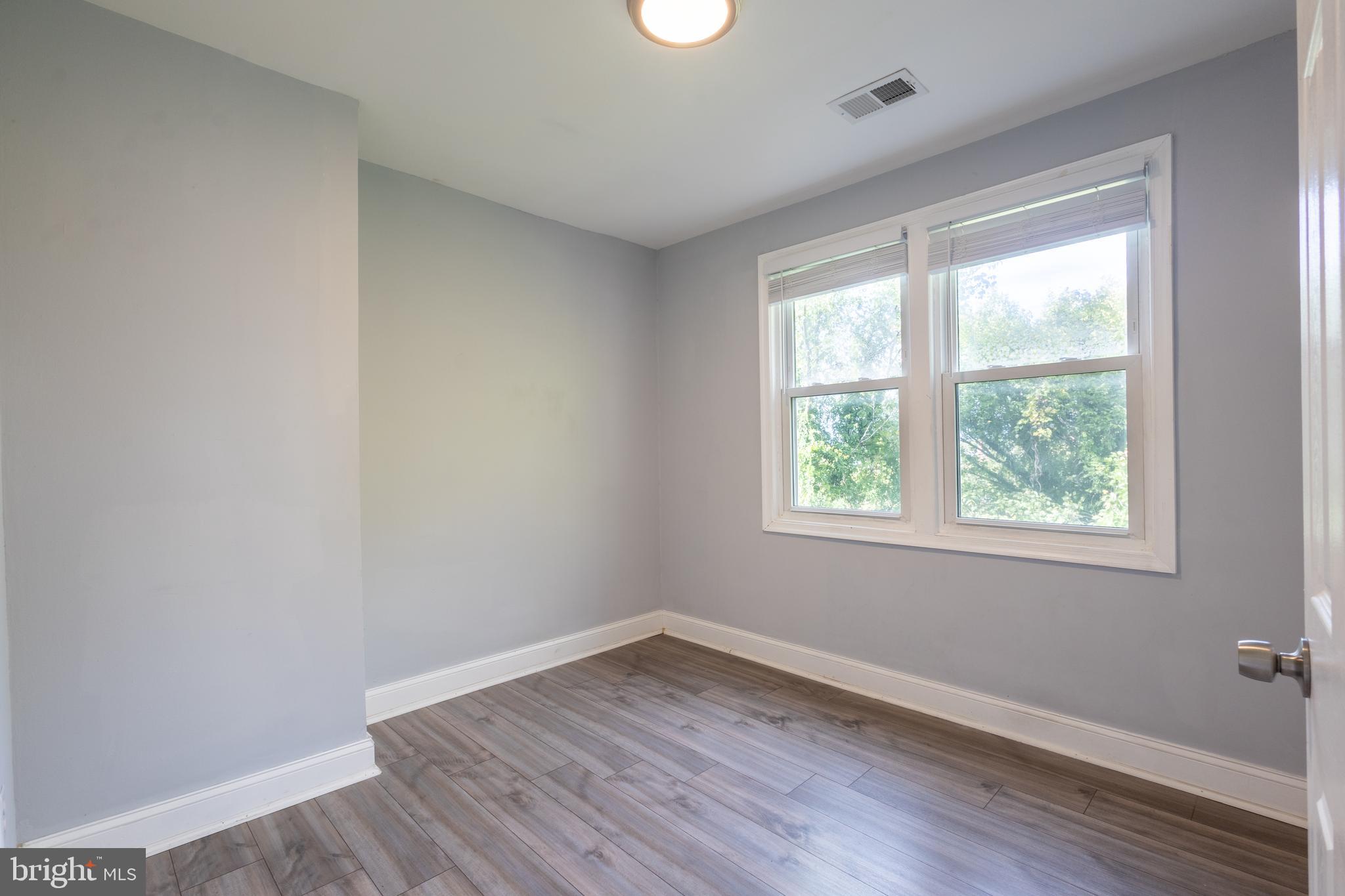 5532 B Street Southeast Washington, DC 20019 - Photo 5 of 19 a view of an empty room with wooden floor and a window