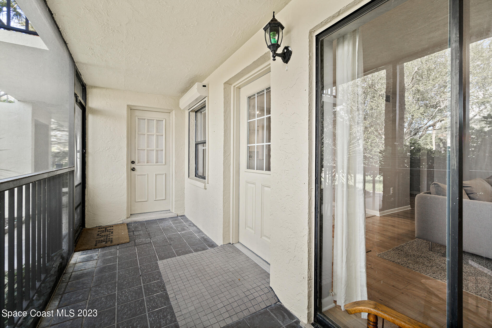 500 Catalina Road, Unit 103 Cocoa Beach, FL 32931 - Photo 7 of 28 a view of a hallway with wooden floor and glass door