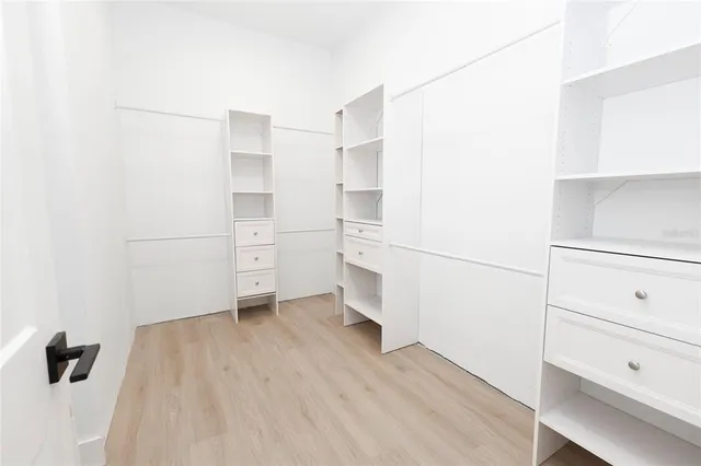 a room with a walk in closet and wooden floor