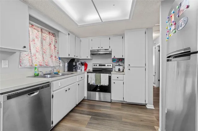 a kitchen with white cabinets and white appliances
