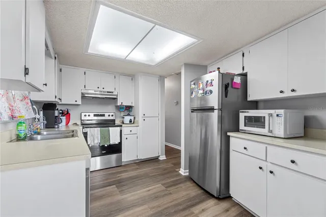 a kitchen with granite countertop stainless steel appliances and wooden cabinets