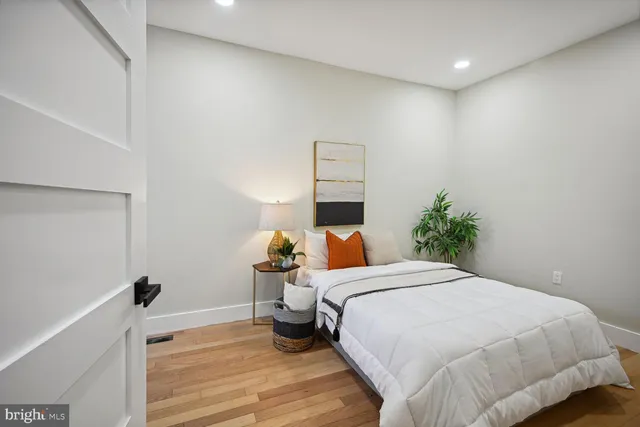 a bedroom with a bed and wooden floor