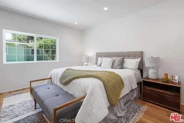 a bedroom with a bed and wooden floor