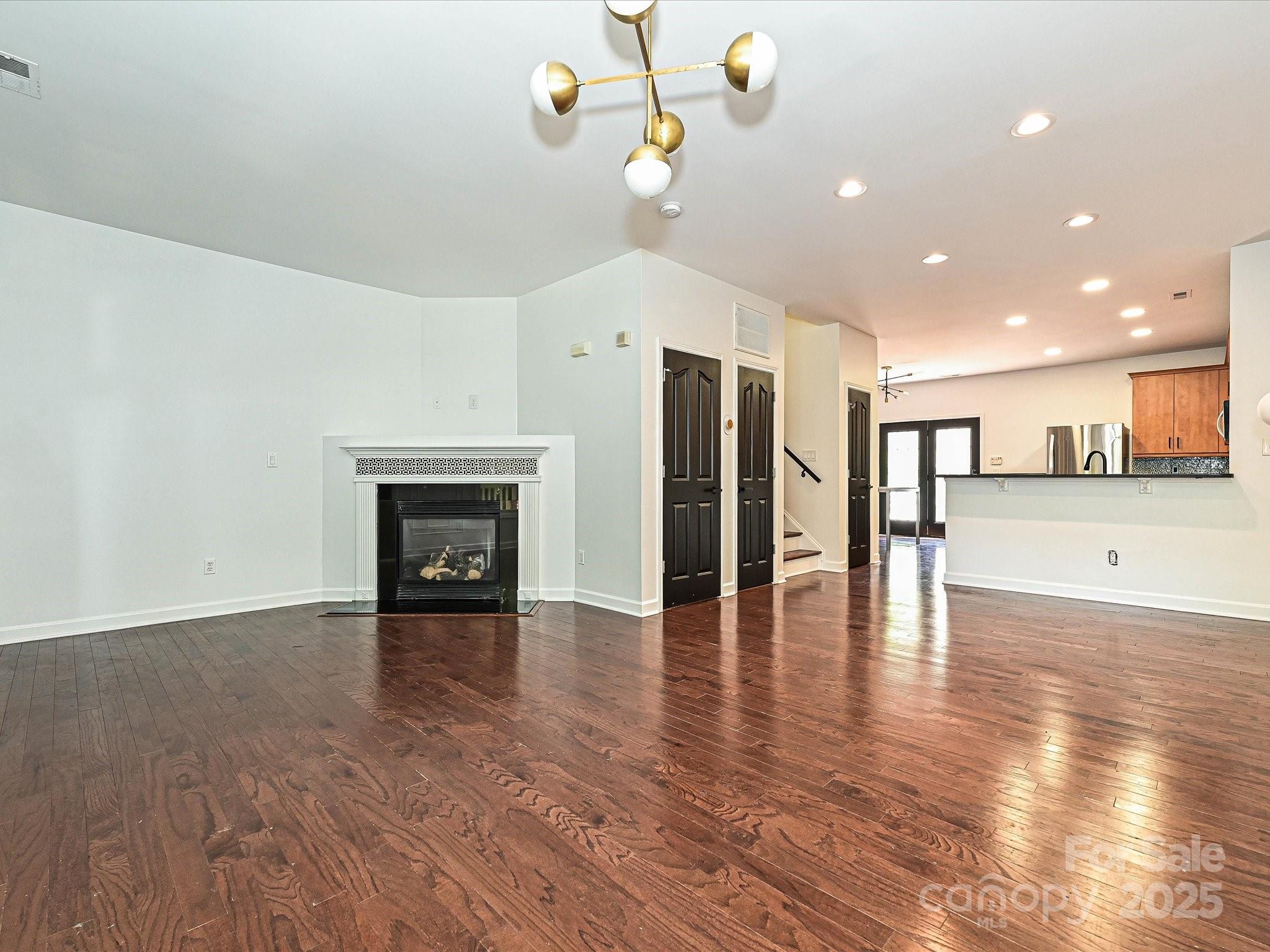 1035 Market Street Fort Mill, SC 29708 - Photo 6 of 28 a view of a livingroom with a fireplace a ceiling fan and kitchen view