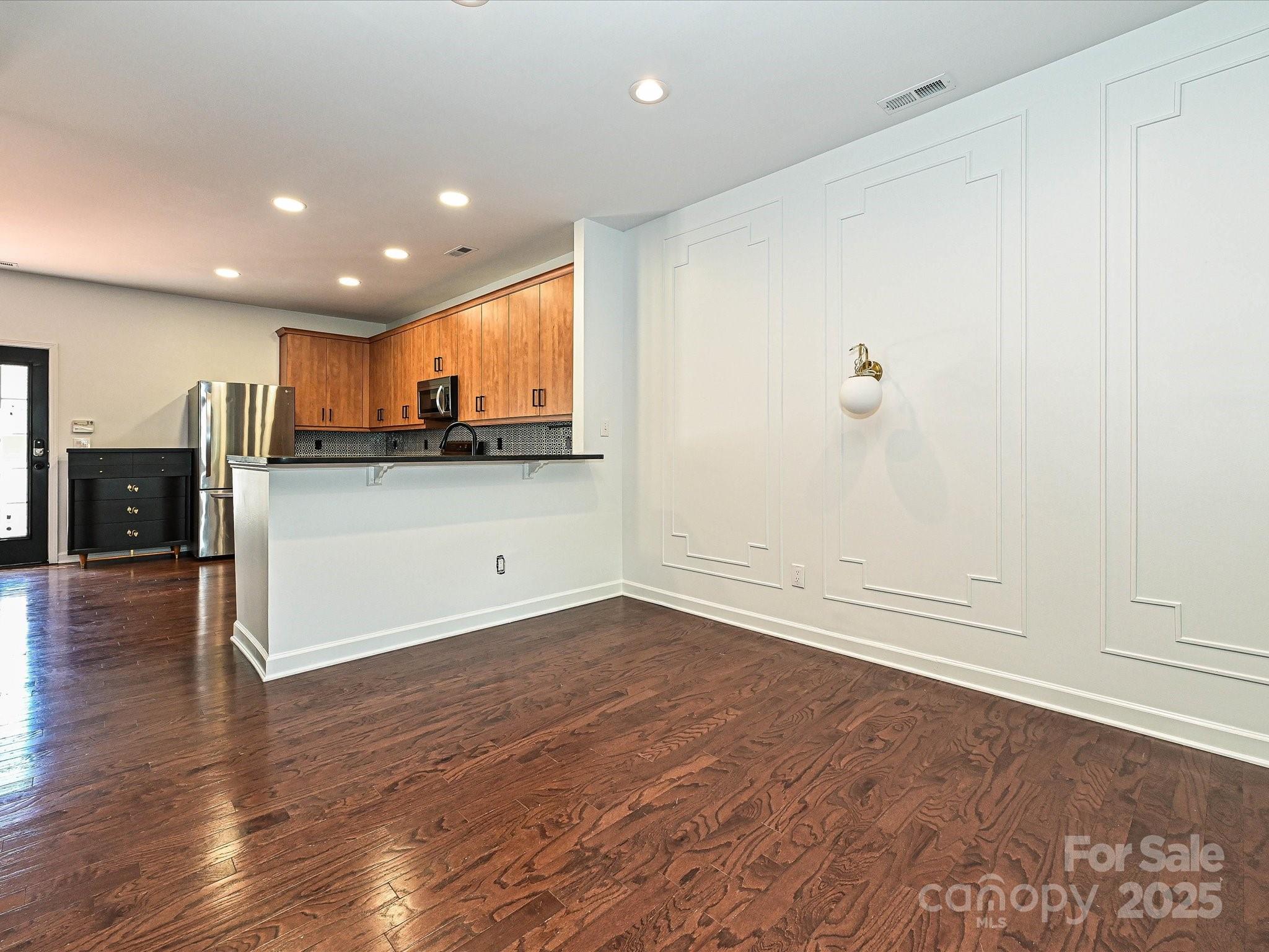 1035 Market Street Fort Mill, SC 29708 - Photo 7 of 28 an empty room with wooden floor and kitchen view