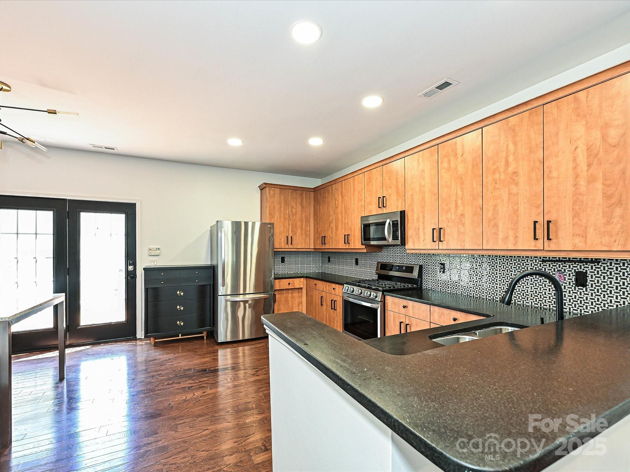 1035 Market Street Fort Mill, SC 29708 - Photo 8 of 28 a kitchen with stainless steel appliances granite countertop a sink a stove and a refrigerator with wooden floor