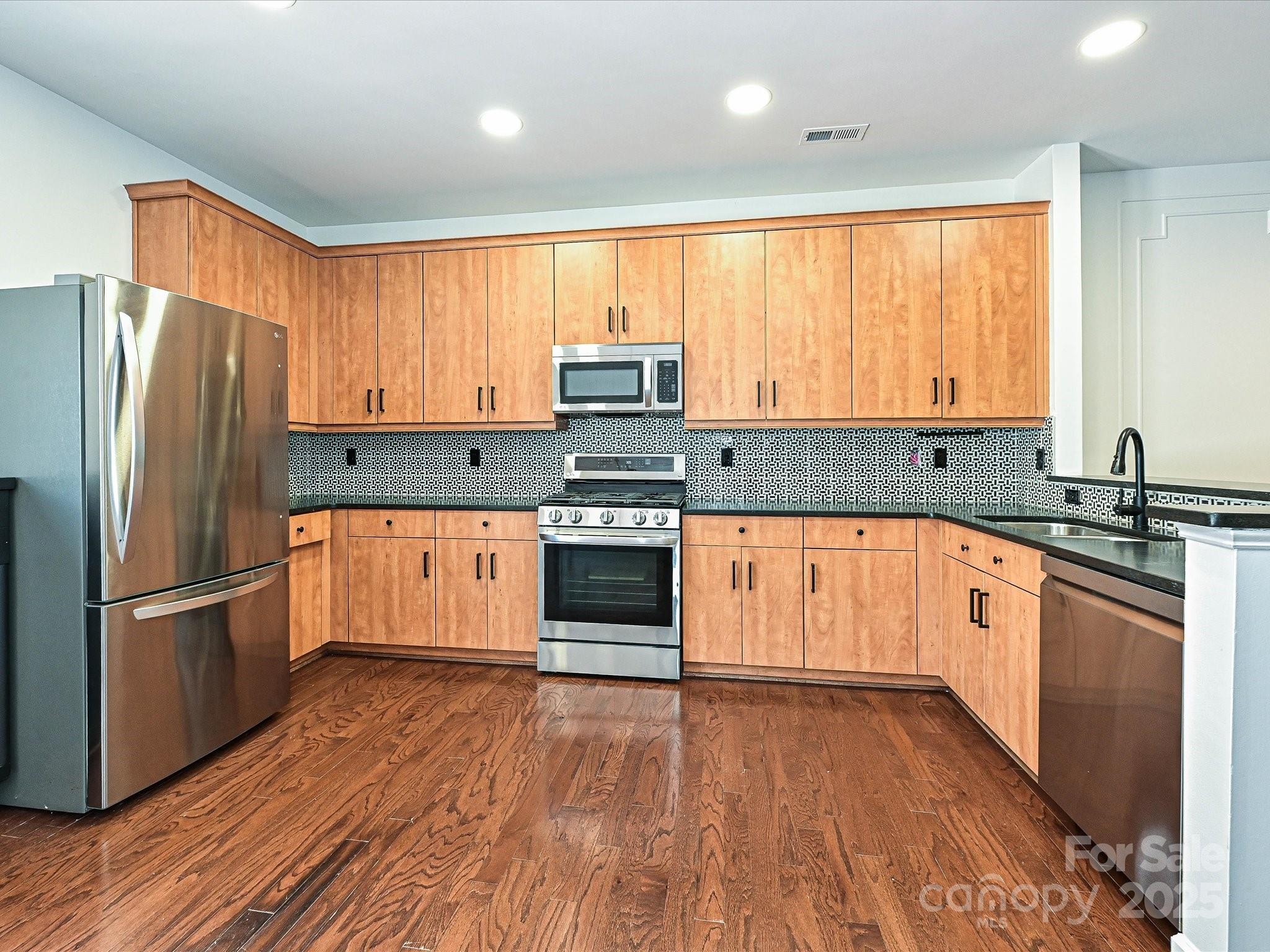 1035 Market Street Fort Mill, SC 29708 - Photo 9 of 28 a kitchen with stainless steel appliances granite countertop a refrigerator a sink dishwasher a stove and white countertops with wooden floor