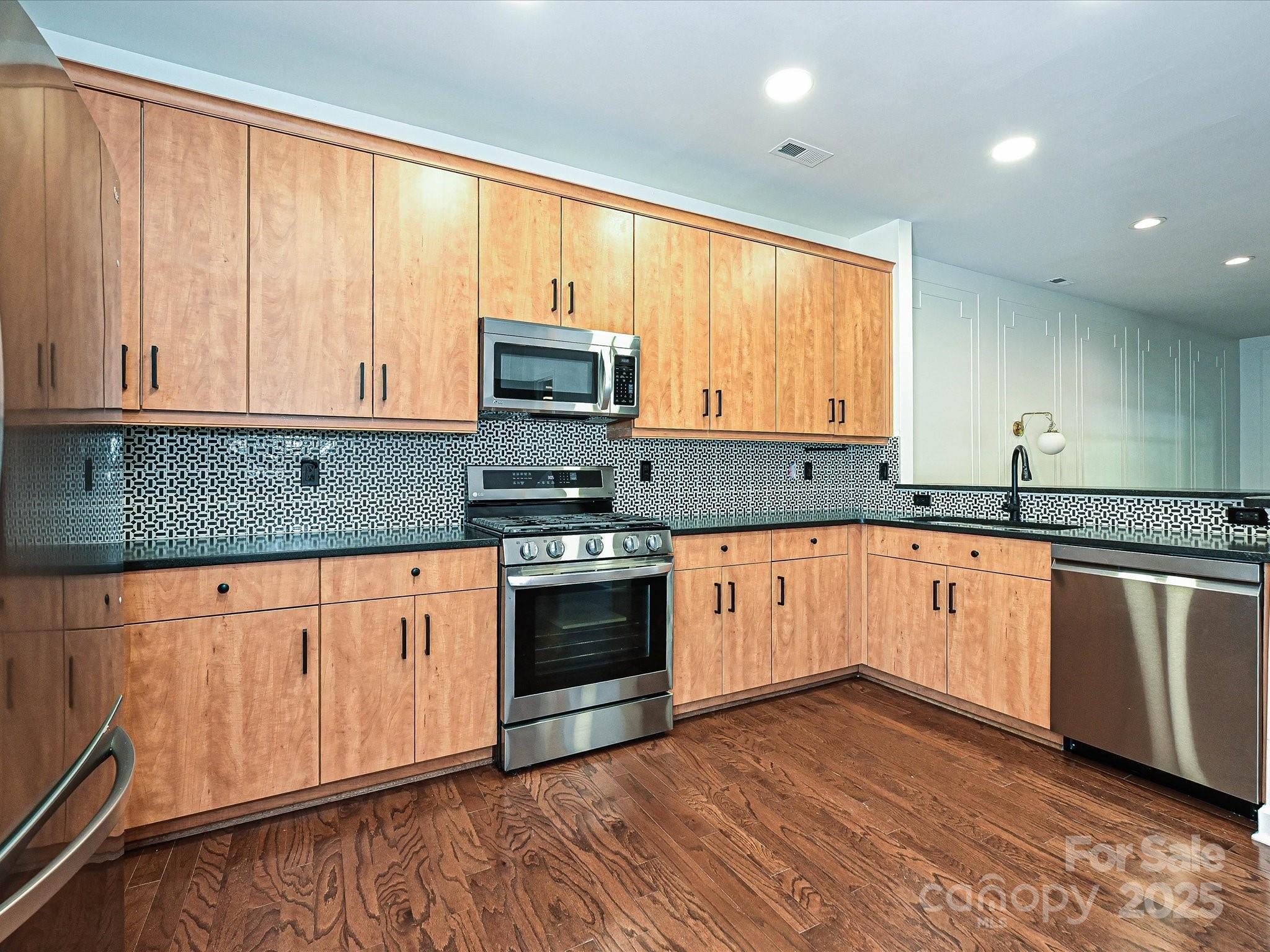 1035 Market Street Fort Mill, SC 29708 - Photo 10 of 28 a kitchen with stainless steel appliances granite countertop wooden cabinets a stove a sink and a window