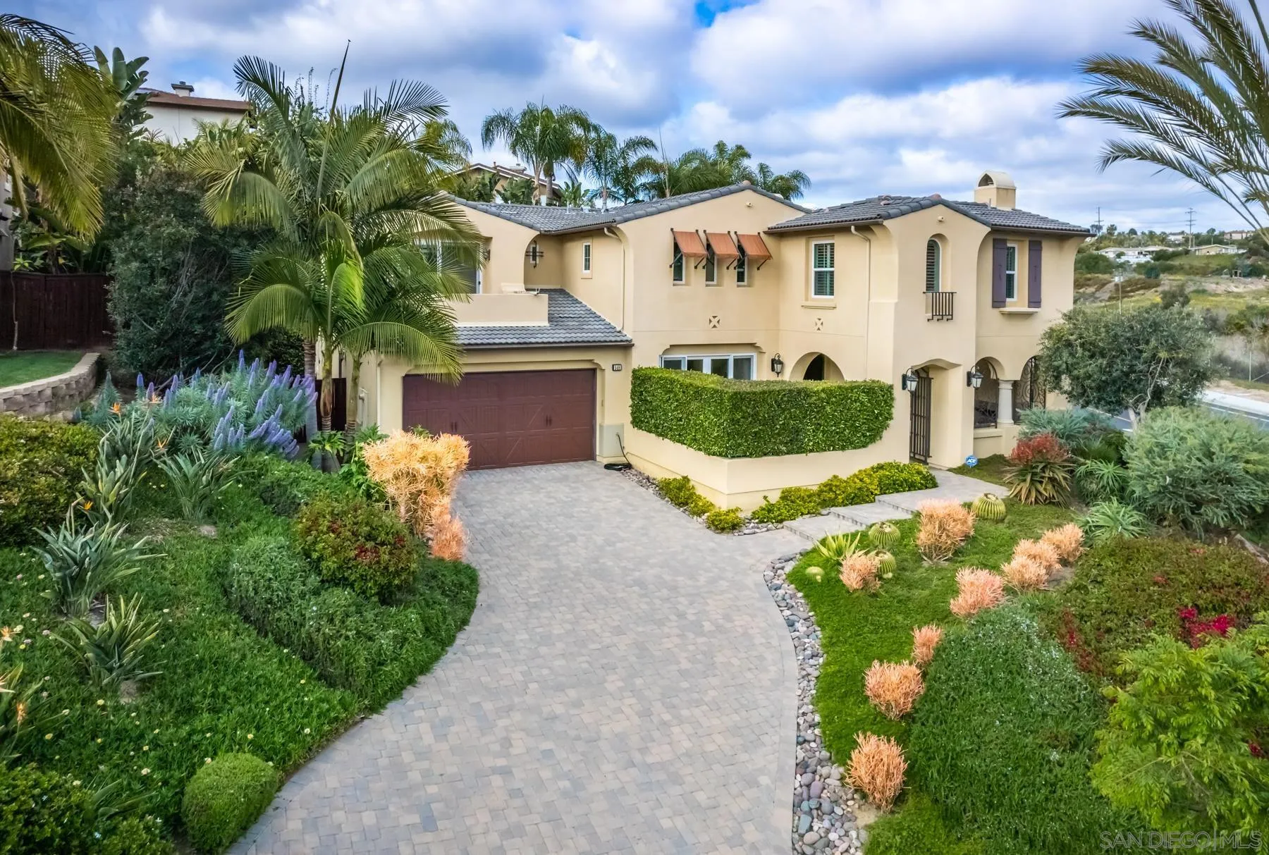 a front view of a house with a yard and potted plants