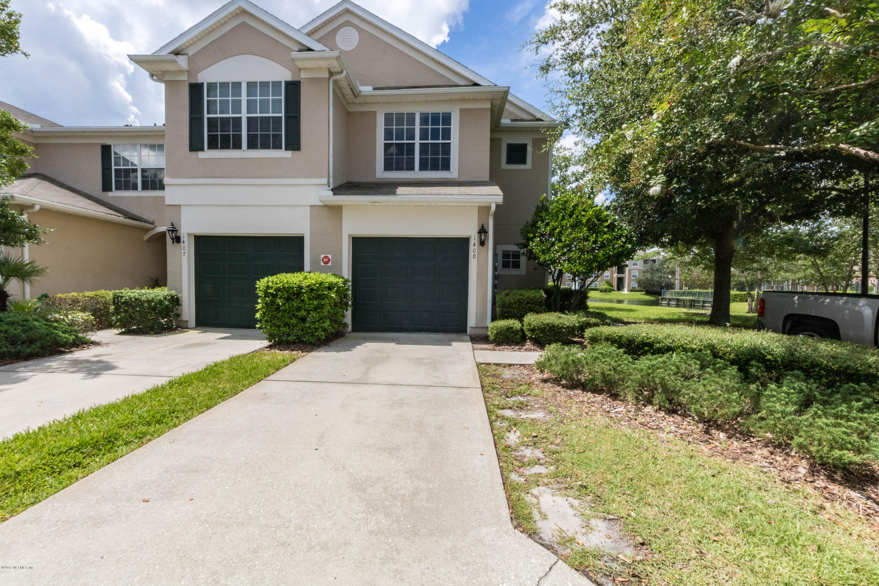 7990 Baymeadows Road East, Unit 1408 Jacksonville, FL 32256 - Photo 1 of 36 a front view of a house with a yard and a garage