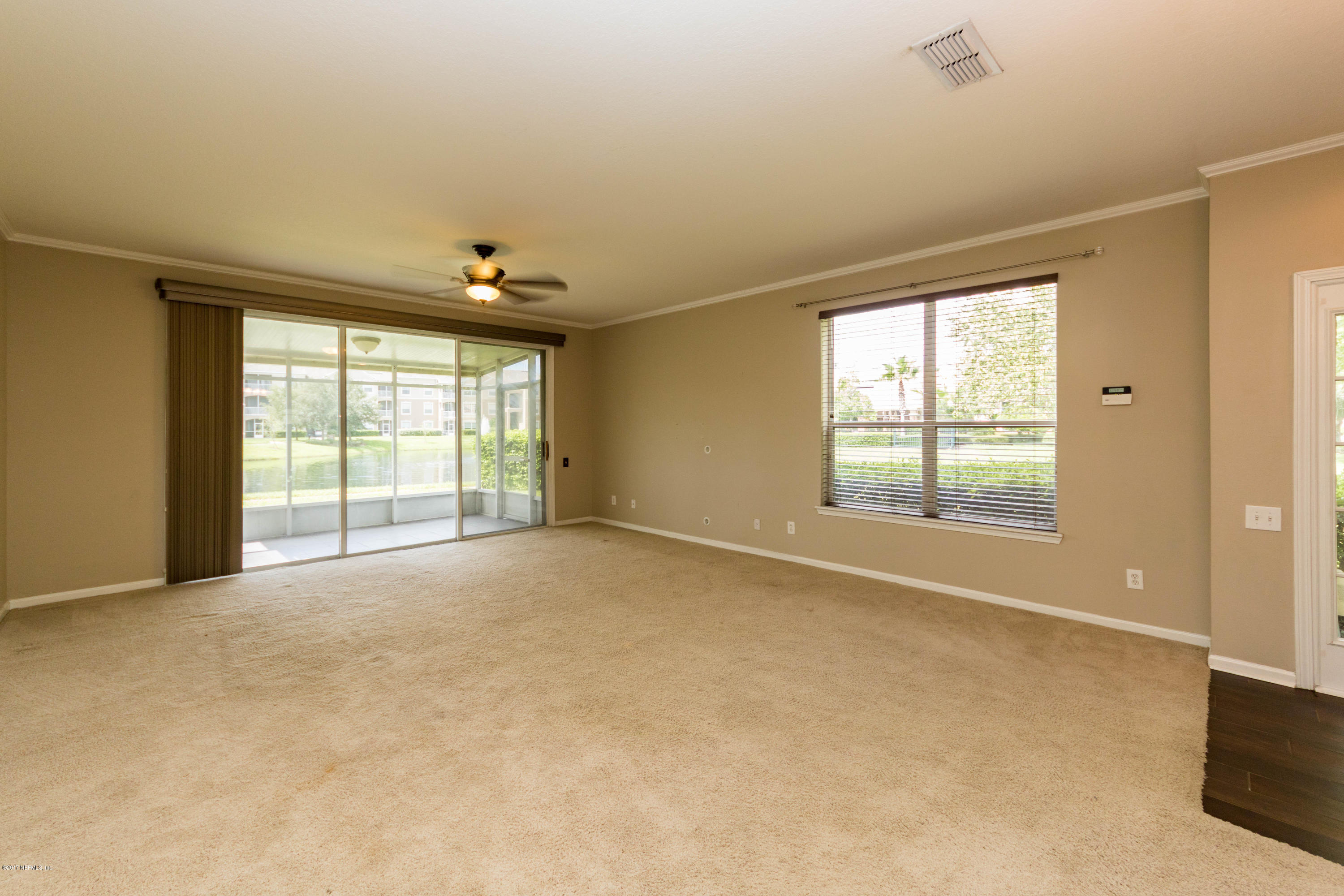 7990 Baymeadows Road East, Unit 1408 Jacksonville, FL 32256 - Photo 15 of 36 an empty room with windows and chandelier fan