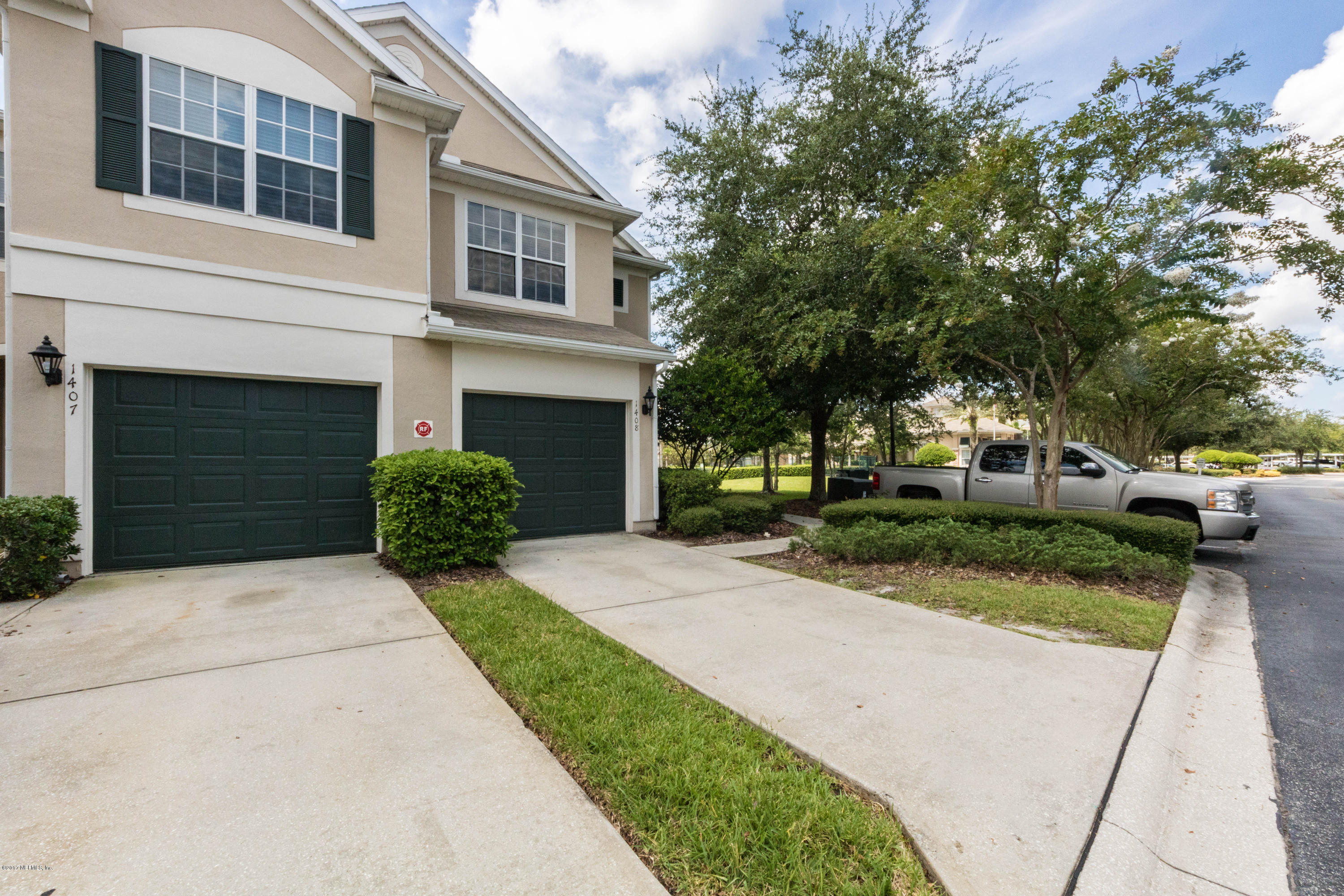 7990 Baymeadows Road East, Unit 1408 Jacksonville, FL 32256 - Photo 2 of 36 a front view of a house with a yard and garage