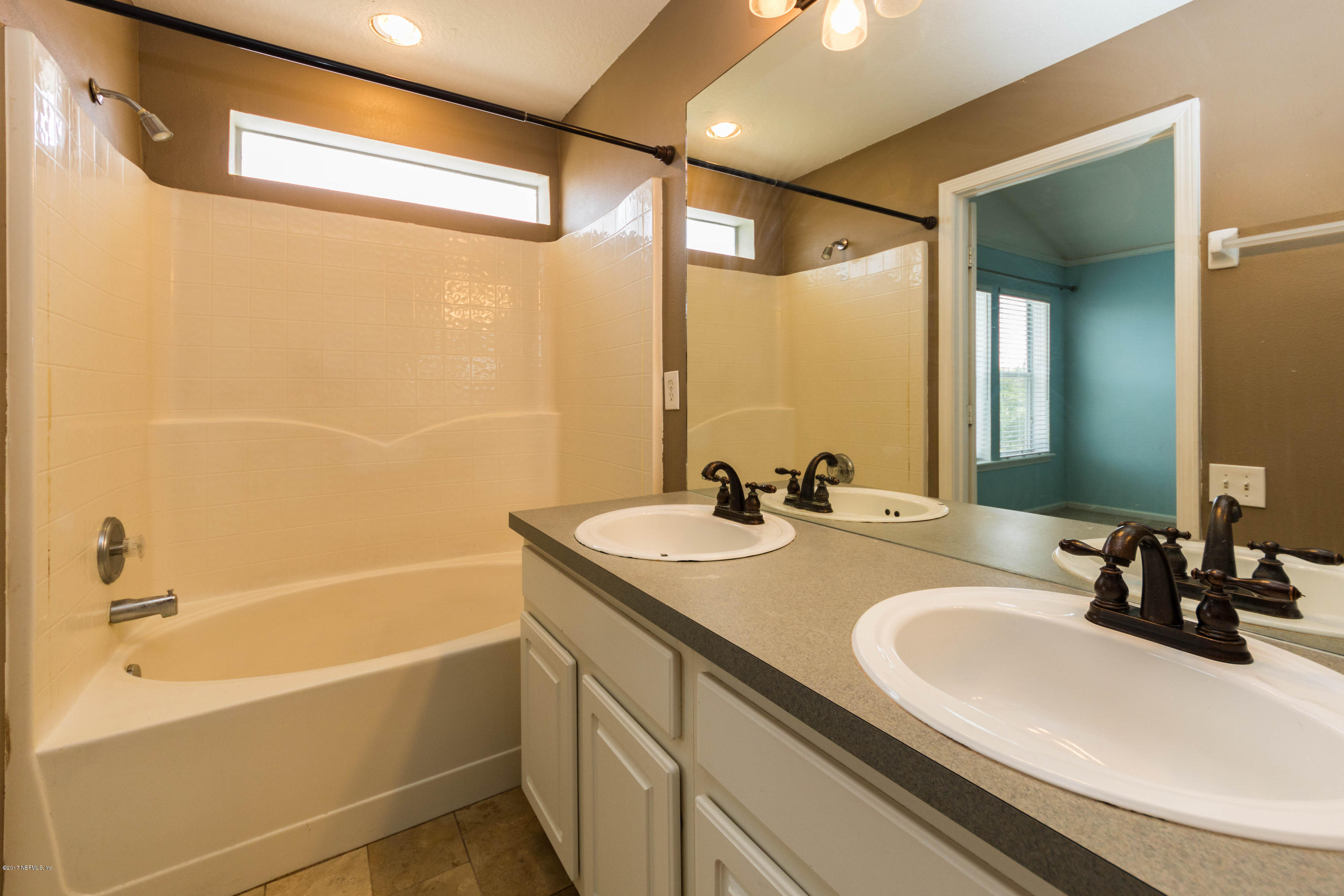 7990 Baymeadows Road East, Unit 1408 Jacksonville, FL 32256 - Photo 26 of 36 a bathroom with a granite countertop sink and a mirror