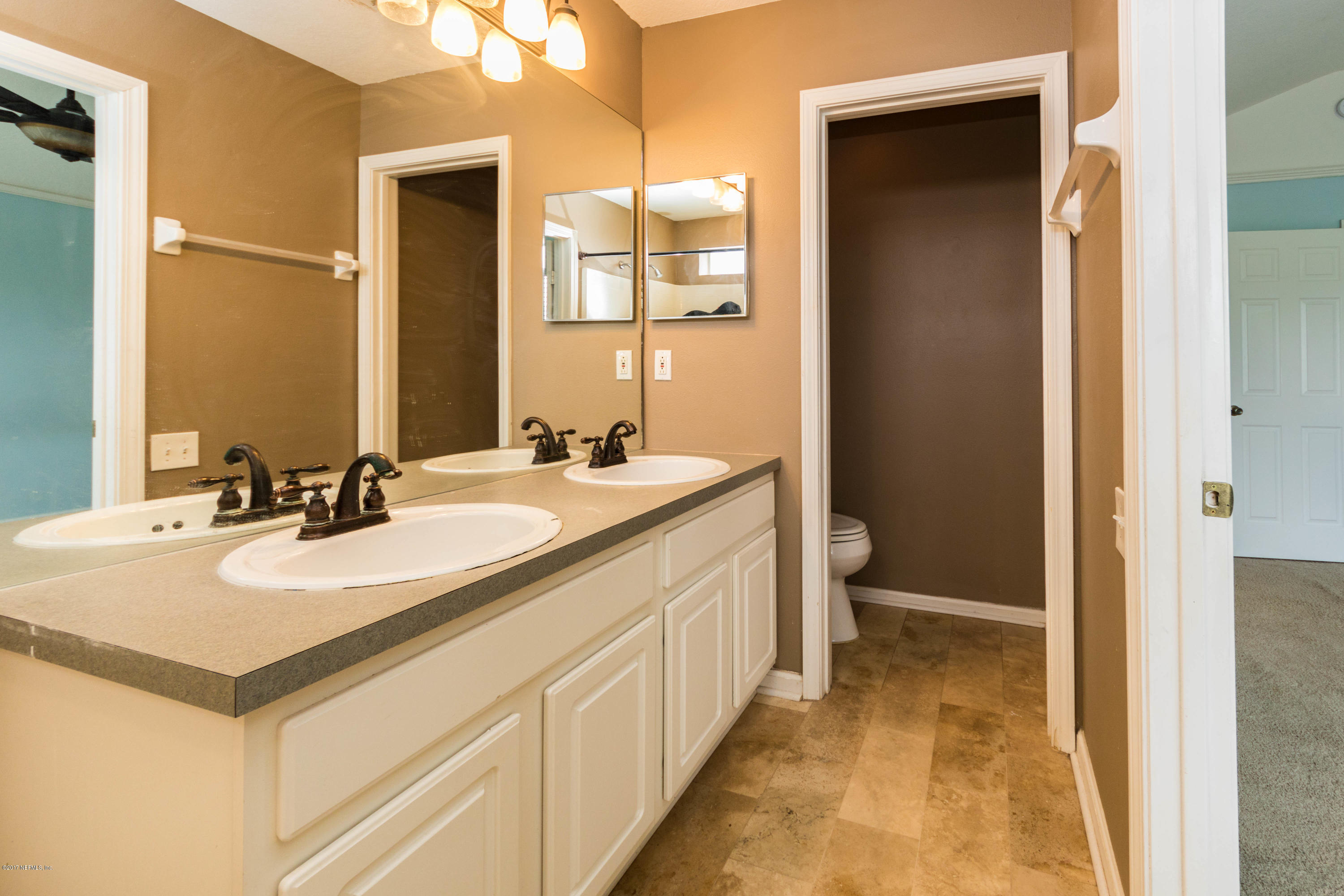 7990 Baymeadows Road East, Unit 1408 Jacksonville, FL 32256 - Photo 27 of 36 a bathroom with a sink a toilet and a mirror