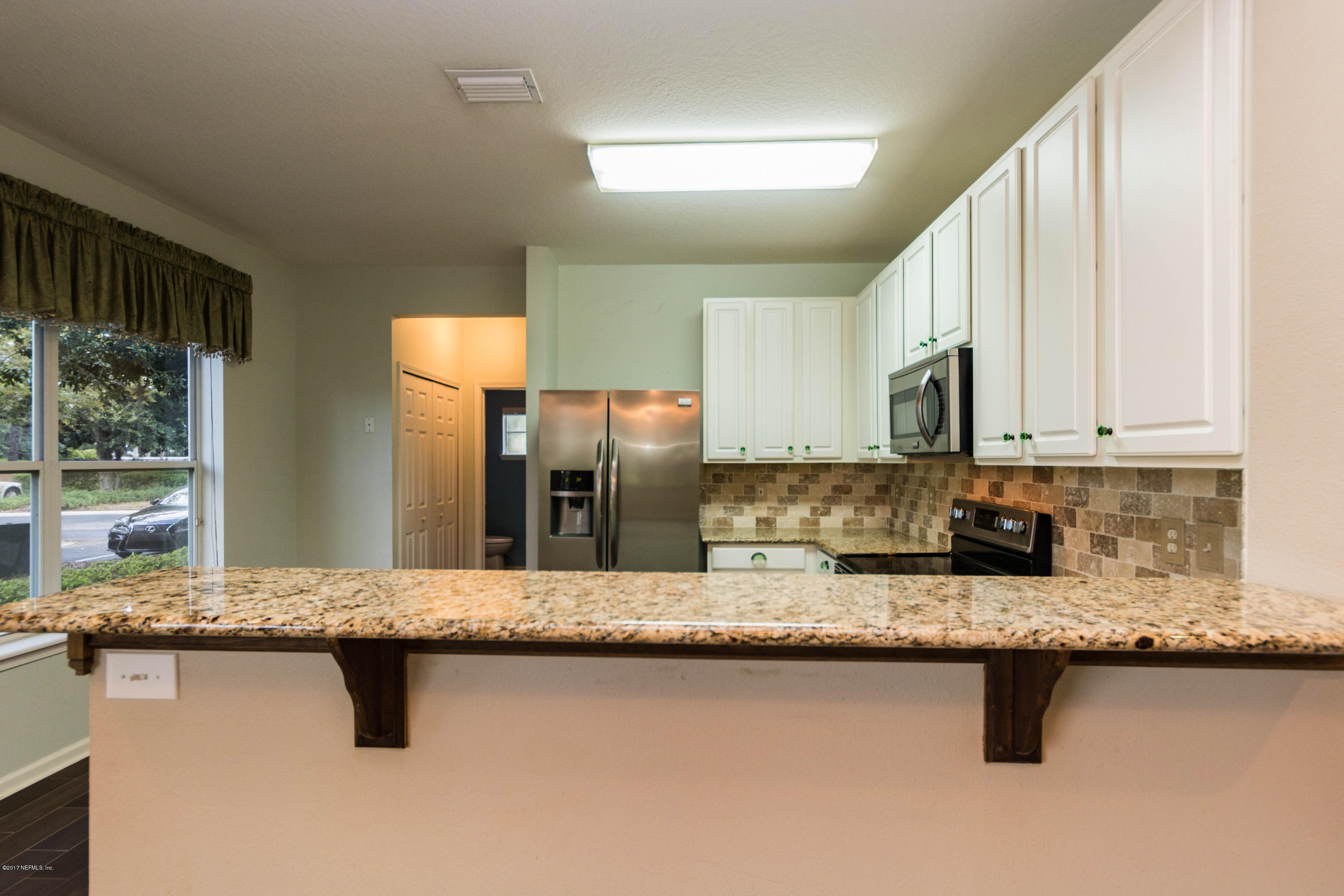 7990 Baymeadows Road East, Unit 1408 Jacksonville, FL 32256 - Photo 7 of 36 a kitchen with stainless steel appliances granite countertop a sink a stove and a refrigerator