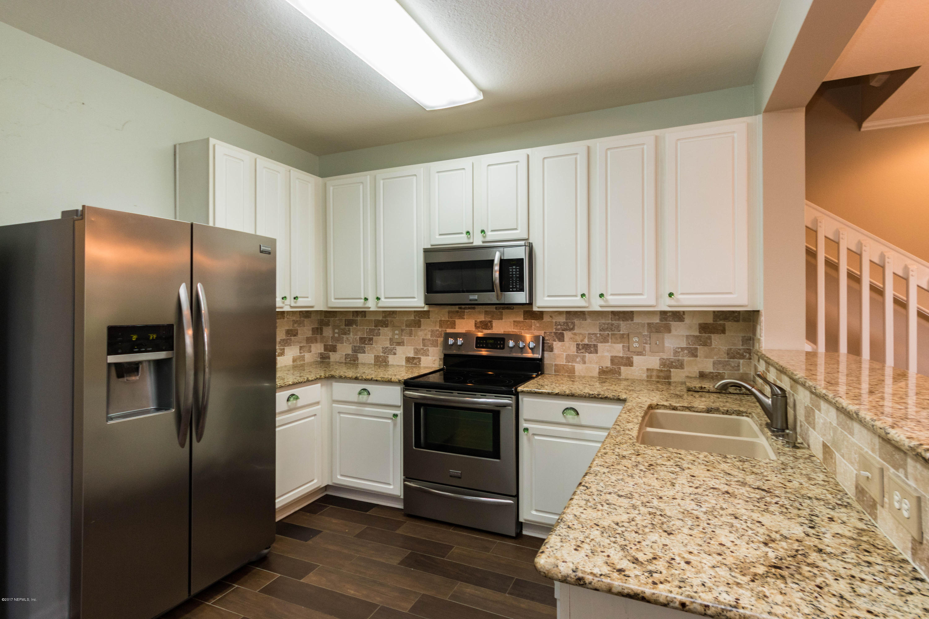 7990 Baymeadows Road East, Unit 1408 Jacksonville, FL 32256 - Photo 8 of 36 a kitchen with granite countertop a refrigerator stove and microwave