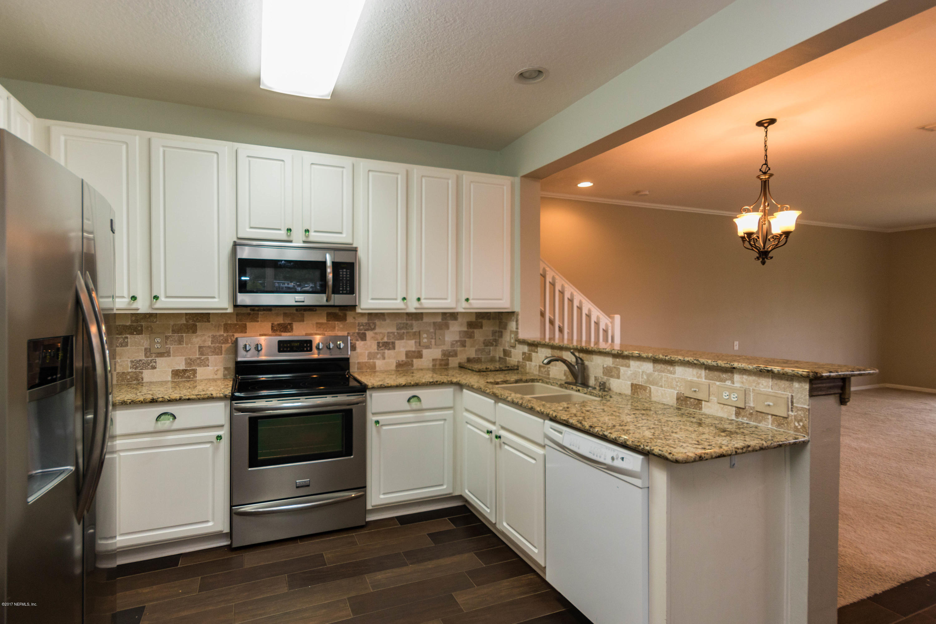 7990 Baymeadows Road East, Unit 1408 Jacksonville, FL 32256 - Photo 9 of 36 a kitchen with stainless steel appliances a sink stove and microwave