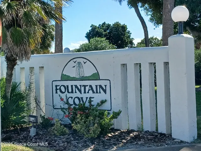 a view of sign board with potted plants
