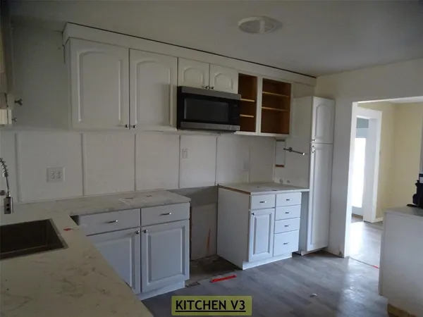 a kitchen with stainless steel appliances white cabinets and a refrigerator