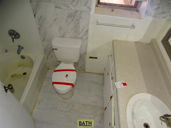 view of bathroom with a tub and toilet