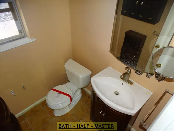 a bathroom with a toilet sink and mirror