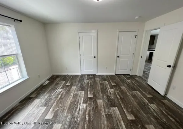 a view of a room with wooden floor and white walls