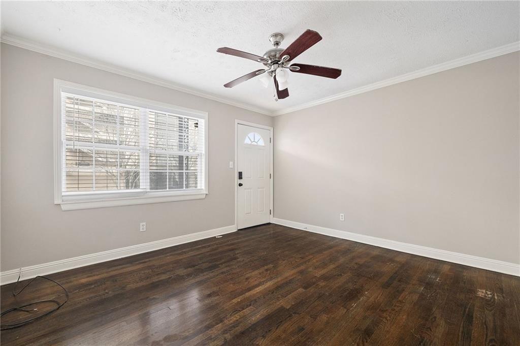 21 Delmont Drive Northeast, Unit 7 Atlanta, GA 30305 - Photo 13 of 22 an empty room with wooden floor ceiling fan and windows