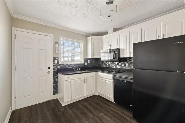 a kitchen with stainless steel appliances granite countertop a refrigerator and a stove top oven