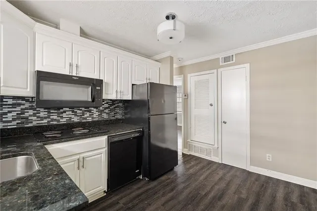 a kitchen with stainless steel appliances granite countertop a refrigerator and a stove top oven
