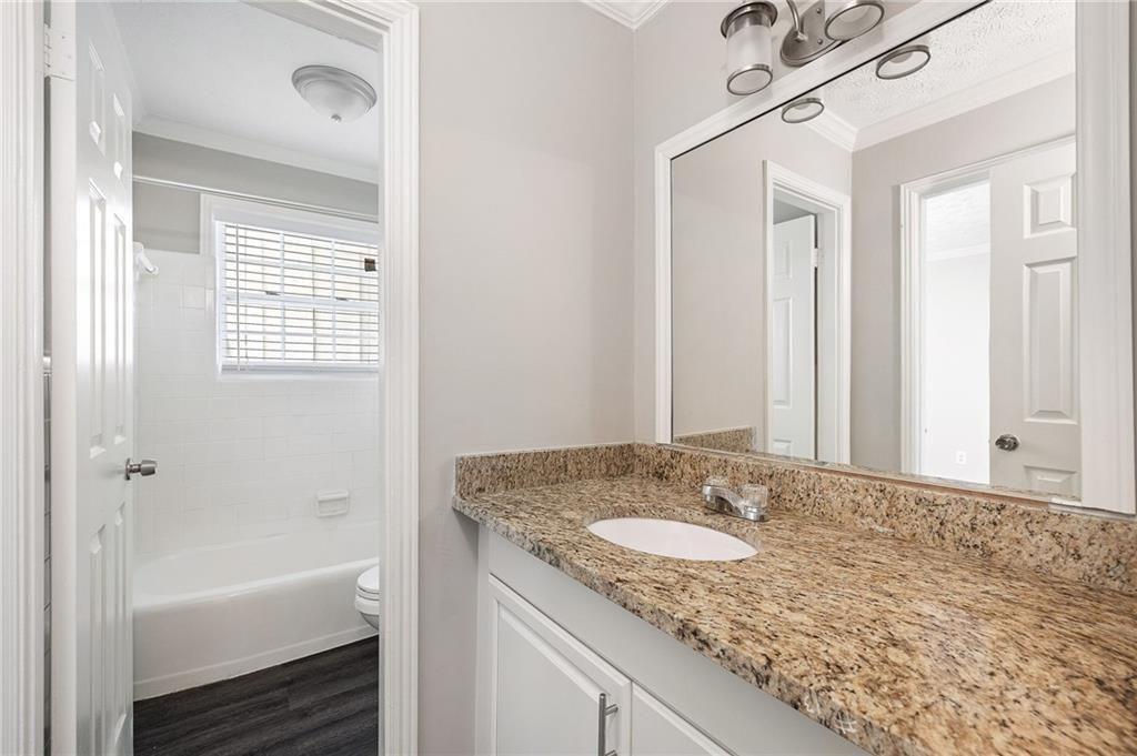 21 Delmont Drive Northeast, Unit 7 Atlanta, GA 30305 - Photo 19 of 22 a bathroom with a granite countertop sink and a mirror