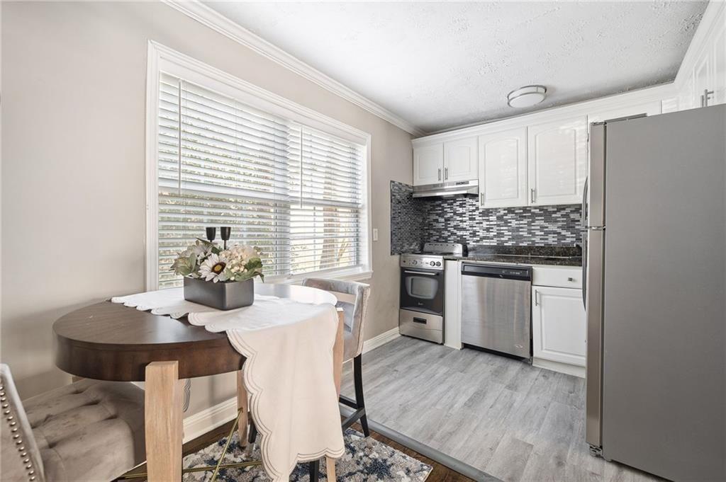 21 Delmont Drive Northeast, Unit 7 Atlanta, GA 30305 - Photo 6 of 22 a kitchen with appliances cabinets and wooden floor