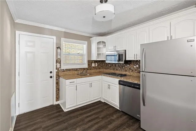 a kitchen with stainless steel appliances a refrigerator sink and microwave