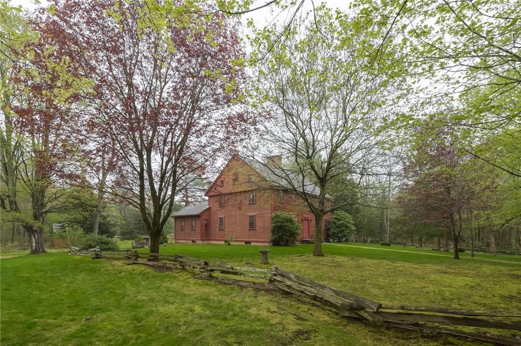 a front view of a house with a yard and large trees