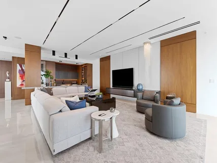 a dining room with furniture a potted plant and a flat screen tv