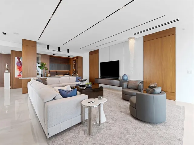 a dining room with furniture a potted plant and a flat screen tv