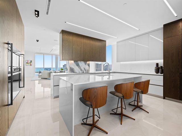 a dining room with furniture a chandelier and wooden floor