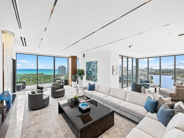 a living room with furniture and floor to ceiling windows